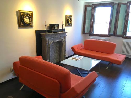 a living room with two red chairs and a fireplace at The Other Serenissima (With A/C) in Venice