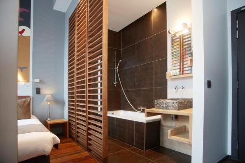 a bathroom with a tub and a sink in a room at Boutique Hotel Saint-Géry in Brussels