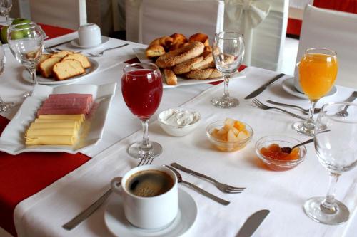 einen Tisch mit einem weißen Tischtuch mit Speisen und Getränken in der Unterkunft Famissi Eden Hotel in Kalambaka