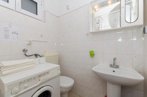Baño blanco con lavabo y aseo en Apartments Davorka, en Gdinj