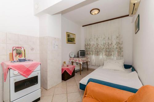 Habitación pequeña con 1 cama y 2 mesas en Apartments Davorka, en Gdinj