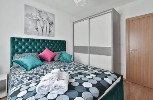 a bedroom with a large bed with colorful pillows at Lux Apartman Daria in Zlatibor