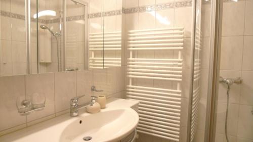 a white bathroom with a sink and a shower at Spectacular View & Central Location in Davos in Davos