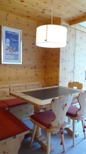 a dining room with a table and chairs and a light at Spectacular View & Central Location in Davos in Davos