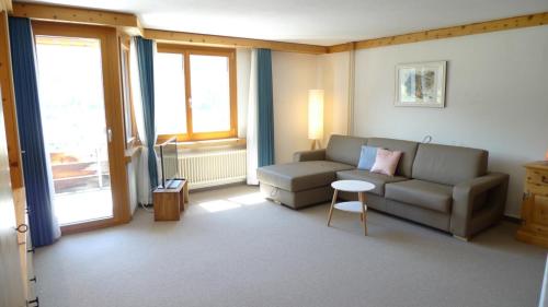 a living room with a couch and a table at Spectacular View & Central Location in Davos in Davos