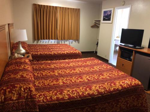 a hotel room with two beds and a television at Evergreen Lodge in Mount Shasta