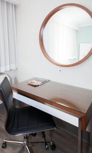 a mirror sitting on top of a desk with a chair at Pasadena Rose & Crown Hotel in Pasadena