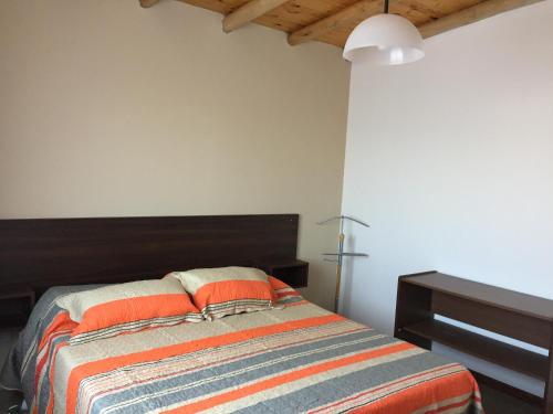 1 dormitorio con 1 cama con manta naranja y azul en Departamentos 3 de Febrero en San Rafael