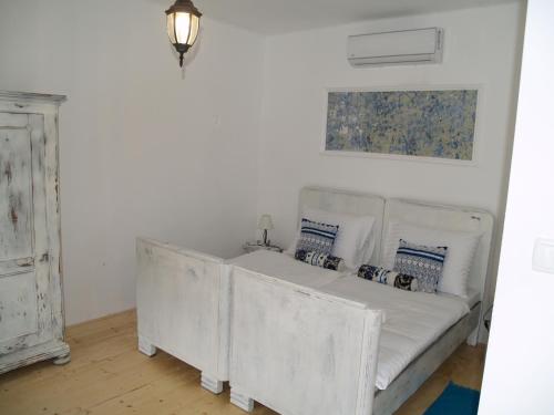a white couch with pillows on it in a room at Pannonia Terranova in Vardarac