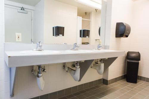 a bathroom with two sinks and two mirrors at American Hotel Hostel in Seattle