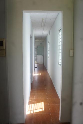 a hallway with white walls and a tile floor at BangBang Motel in Can Tho