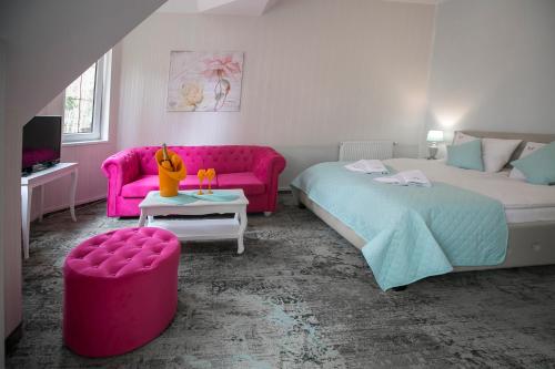 sypialnia z 2 łóżkami i różową kanapą w obiekcie Villa Justyna w Pobierowie