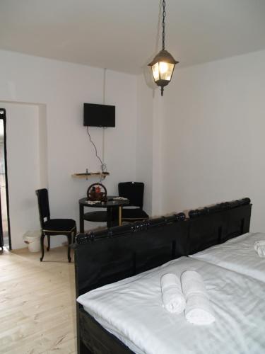 a bedroom with a bed with white sheets and a lamp at Pannonia Terranova in Vardarac