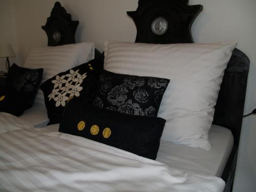 a bed with black and white pillows on it at Pannonia Terranova in Vardarac
