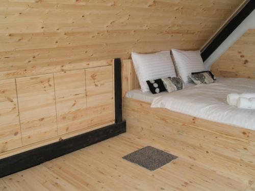 a bedroom in a log cabin with a bed at Pannonia Terranova in Vardarac
