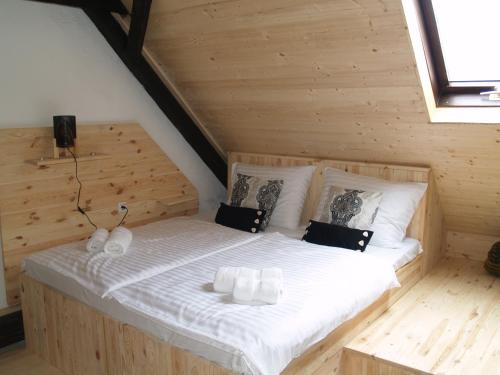 a bedroom with a bed in a log cabin at Pannonia Terranova in Vardarac