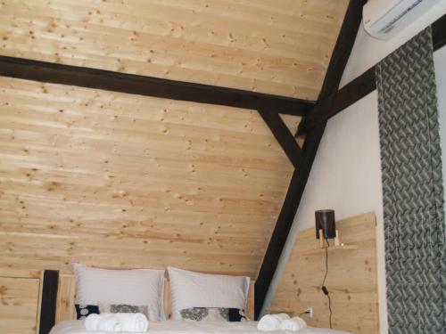 a bedroom with a wooden ceiling and two beds at Pannonia Terranova in Vardarac