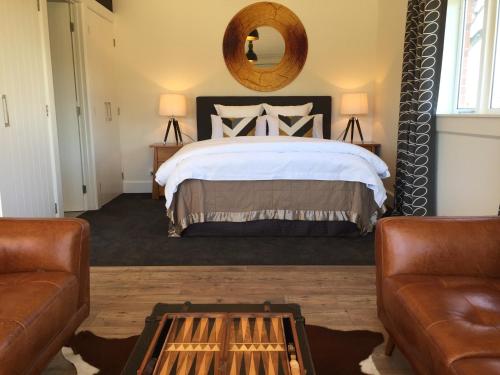 a bedroom with a large bed and a mirror at The Studio at Northfield in Methven