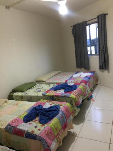Pousada Oluap في مايريبورا: سريرين في غرفة عليها ملابس