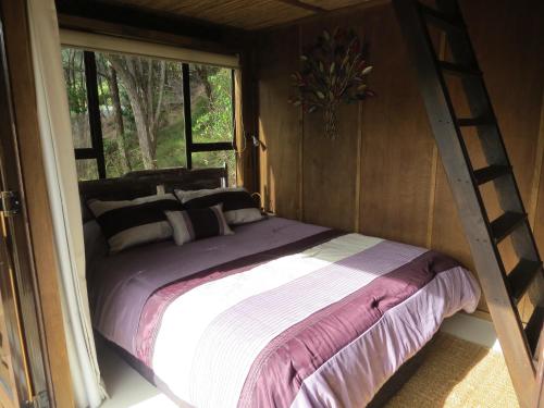 uma cama num quarto com uma janela em The Bali Room em Coromandel Town