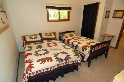 1 dormitorio con 2 camas y ventana en Ranch-Style Seidls Home en Namekagon