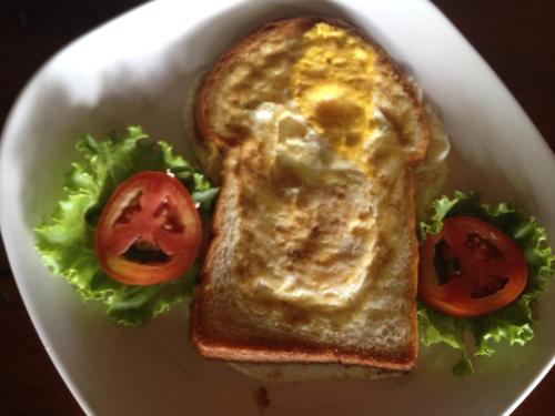 un piatto bianco con un panino con un uovo e pomodori di Poseidon Resort a Ko Tao