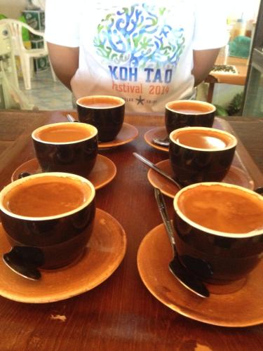 un gruppo di tazze di caffè su un tavolo di legno di Poseidon Resort a Ko Tao