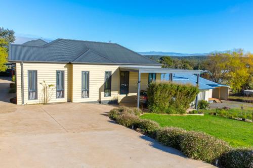 a white house with a black roof at Alfies on Albert Daylesford in Daylesford