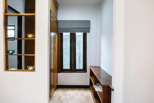 a hallway with a window and a wooden shelf at Billabong Hotel and Cafe in Baan Tai