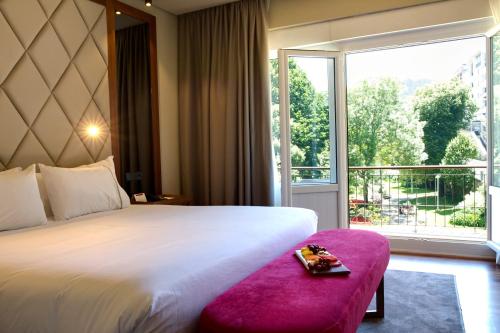 a hotel room with a bed and a large window at Hotel Silken Palacio Uribarren in Lekeitio