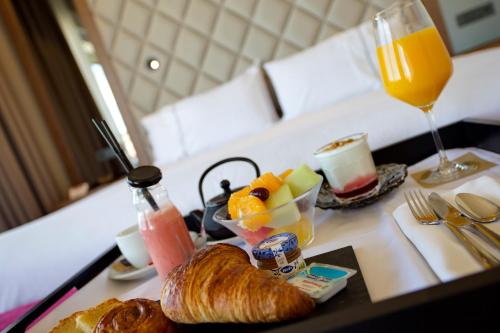 a tray with a breakfast of croissants and a glass of orange juice at Hotel Silken Palacio Uribarren in Lekeitio