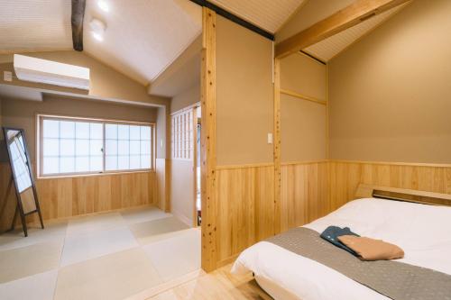 a bedroom with a bed in a room with a window at Miro Saiinnishi Imadacho Tei in Kyoto