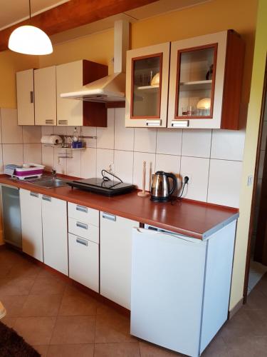 une cuisine avec des placards blancs et un comptoir dans l'établissement Ahorn II, à Rydzewo