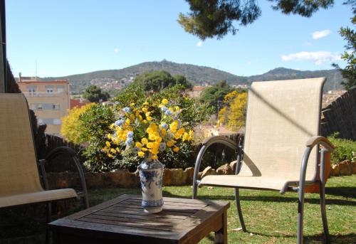 a vase of flowers on a table next to a chair at Hotel El Castell in Sant Boi del Llobregat