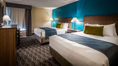 two beds in a hotel room with blue walls at Best Western Plus Yadkin Valley Inn & Suites in Jonesville