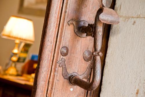 an old wooden door with a rusty door handle at La Casa del Organista in Santillana del Mar