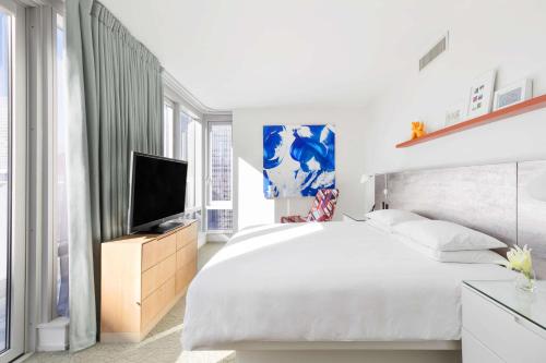 a white bedroom with a bed and a television at Hyatt Centric Times Square New York in New York