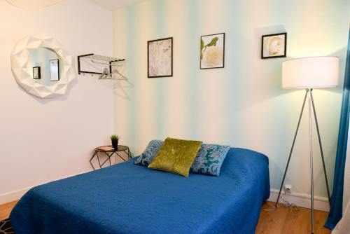 ein Schlafzimmer mit einem blauen Bett und einer Lampe in der Unterkunft Studio Ramblas Centre Toulouse in Toulouse