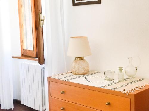 a table with a lamp on top of a dresser at Agriturismo Testalepre in Greve in Chianti