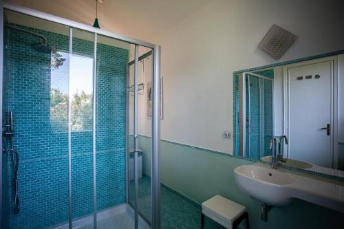 a bathroom with a glass shower and a sink at Villa Alma in Santa Margherita di Pula