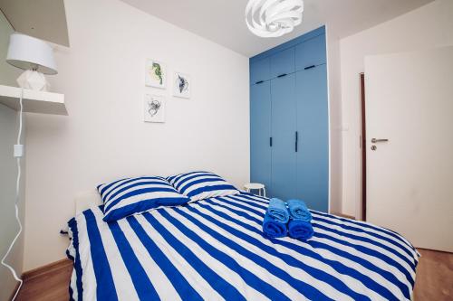 コウォブジェクにあるApartament Blue Point 102 PREMIUMのベッドルーム1室(青と白のストライプのベッド1台付)