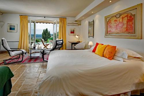 サン・ポール・ド・ヴァンスにあるLuxury Pool Apartment at Villa Seburgaのベッドルーム(大型ベッド1台付)、リビングルームが備わります。