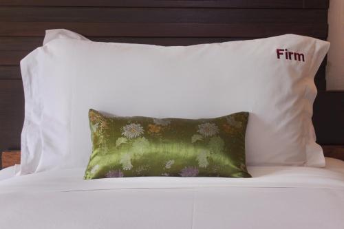 a white bed with two pillows on top of it at Bamboori Boutique Resort in Chiang Mai
