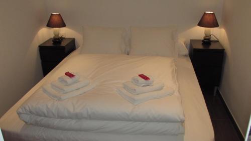 a white bed with towels on it with two lamps at Casa Cosy in Valencia