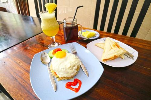 a table with two plates of food and a drink at Rena Segara House Kuta in Kuta