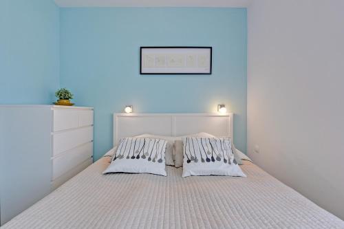 a bedroom with a bed with a blue wall at Baltic Sunrise - Apartamenty przy plaży in Jelitkowo