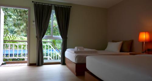 a bedroom with two beds and a large window at U Tiny Boutique Hotel Suvarnabhumi Bangkok - SHA Plus in Lat Krabang