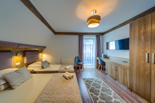 a bedroom with a bed and a living room at Dom Wypoczynkowy Stokrotka in Białka Tatrzanska