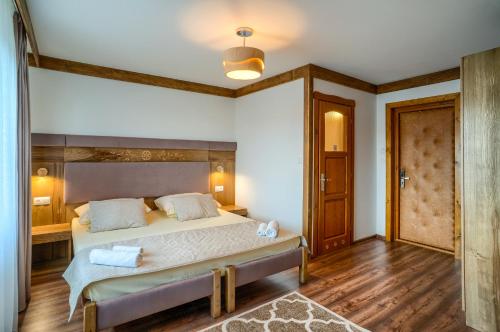 a bedroom with a large bed with a wooden headboard at Dom Wypoczynkowy Stokrotka in Białka Tatrzanska