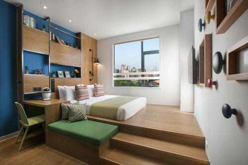 a bedroom with a bed and a desk and a window at Campanile Shanghai Jing An in Shanghai